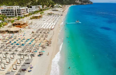 Stacion plazhi me çadra dhe shezlonge në bregdetin shqiptar gjatë sezonit veror 2026