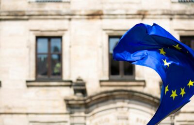 La bandiera dell'Unione Europea davanti a un edificio istituzionale, a simboleggiare la doppia imposizione fiscale tra i paesi dell'UE.