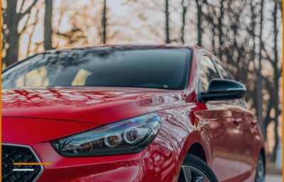 Makinë e kuqe moderne, kompakte, parkuar jashtë, plan nga përpara, pa targa apo stema të dukshme