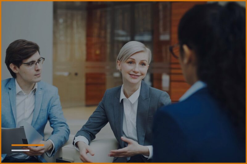 Due consulenti sorridenti stanno parlando con un cliente.