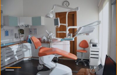 Ambient i një klinike dentare me karrige portokalli dhe pajisje mjekësore