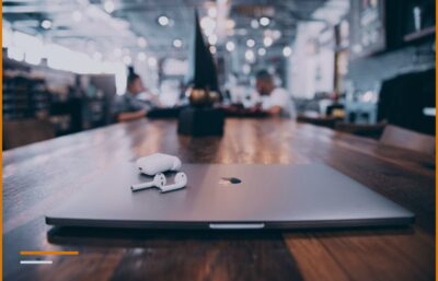 A laptop closed on a wooden table in a small business setting.