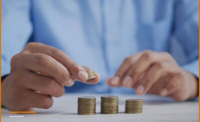 Hands counting growing piles of coins on a table, symbolizing the tax changes of the 2027 fiscal package.