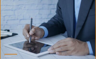 Un datore di lavoro in giacca e cravatta firma su un tablet, a spese del dipendente.